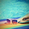 Sunglasses, lilo and hat on the water in hot sunny day. Summer background for traveling and vacation. Holiday idyllic. Royalty Free Stock Photo