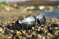 Sunglasses are lying on the rocks, the sun is reflected in them Royalty Free Stock Photo