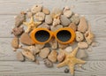 Sunglasses orange color and shells, sea stones and a starfish on Royalty Free Stock Photo