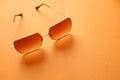 Flat lay  Square sunglasses isolate on a orange background Royalty Free Stock Photo
