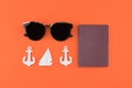 Sunglasses and passport decorate with tiny sailboat and anchor