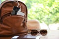Sunglasses, passport, hat and backpack with gadgets on wooden table, space for text. Charging electronics during travel Royalty Free Stock Photo
