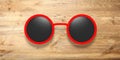 Sunglasses round red with black lens, isolated on a wooden background, 3d illustration.