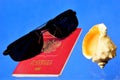 Sunglasses, Russian passport and seashell. A journey in the beach a world of relaxation