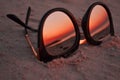 Sunglasses on the sand with the sunset