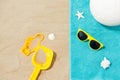 Sunglasses, sand toys and ball on beach towel Royalty Free Stock Photo