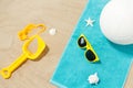 Sunglasses, sand toys and ball on beach towel Royalty Free Stock Photo