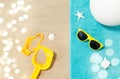 Sunglasses, sand toys and ball on beach towel Royalty Free Stock Photo