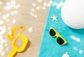 Sunglasses, sand toys and ball on beach towel Royalty Free Stock Photo