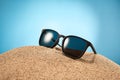 Sunglasses, shades with black frame, lenses in sand. Royalty Free Stock Photo