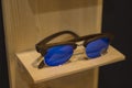 Sunglasses shop with wooden frames in stylish trendy new design on natural wood rack.