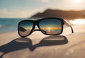 sunglasses sitting on a sandy beach with the sun setting behind them Royalty Free Stock Photo