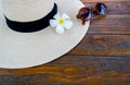 Sunglasses and straw hat with flowers.