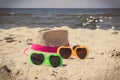 Sunglasses and straw hat on sand at beach. Sun protection while sunbathing. Travel and vacation time Royalty Free Stock Photo