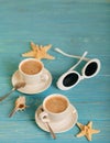 Sunglasses and two white cups of coffee on a wooden blue background. Royalty Free Stock Photo