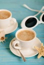 Sunglasses and two white cups of coffee on a wooden blue background. Royalty Free Stock Photo