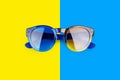 Sunglasses on vibrant blue and yellow background close up top view, fashion sunshades colorful backdrop, trendy modern eyeglasses Royalty Free Stock Photo