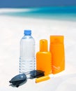 Sunglasses, water and sun protection cream on beac Royalty Free Stock Photo