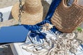 Sunglasses on a white bench with a magazine, rope, hat and bag. Beach holidays, travel, resort Royalty Free Stock Photo
