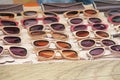Sunglasses in a wooden frame. Many sunglasses. Designer glasses