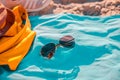 Sunglasses, yellow bag on blue beach towel Royalty Free Stock Photo