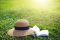 Sunhat and book lying on a lush green garden lawn under the hot rays of the sun Royalty Free Stock Photo