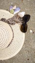 Sunhat, sunglasses and shells on the beach, closeup, 