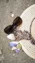 Sunhat, sunglasses and shells on the beach, closeup, 