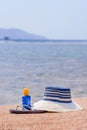 Sunhat, thongs and sunscreen on a beach Royalty Free Stock Photo