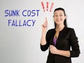 SUNK COST FALLACY exclamation marks phrase on the gray wall Royalty Free Stock Photo