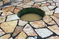 A sunked fire pit on a stone patio filled with water