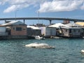 Sunken boats in water behind poor run down houses