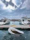 Sunken inflatable boat near a wooden pier with moored yachts