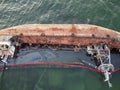 Sunken rusty tanker lying on the washed-up seas off the coast