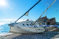Sunken sailing yacht washed ashore landscape on sunny day Shipwreck, insurance Royalty Free Stock Photo
