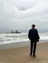 Sunken trawler, shipwreck. Ship Zeila at Skeleton Coast Namibia. Man stands.