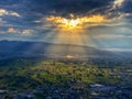 Sunlight breaks through a dark cloud cover.