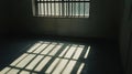 Sunlight is casting shadows of bars from a window onto the floor of a dark room Royalty Free Stock Photo