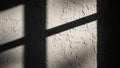 Sunlight Casting Shadows on a Textured Wall Through Window Frame Royalty Free Stock Photo