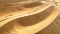 Sunlight casting shadows on undulating golden sand dunes desert abstract Royalty Free Stock Photo