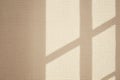 Sunlight casting window shadows on textured beige wall Royalty Free Stock Photo