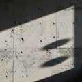 Sunlight casts angular shadows on a textured concrete wall, highlighting its rough Royalty Free Stock Photo