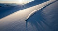 Sunlight Casts Dramatic Shadows Over Pristine Snow Dunes in Winter Landscape Royalty Free Stock Photo