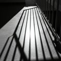Sunlight casts linear shadows from a metal railing onto a smooth, speckled concrete Royalty Free Stock Photo