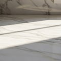Sunlight casts shadows across a smooth, white marble floor with subtle gray veining. Royalty Free Stock Photo