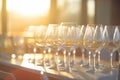 sunlight catching the hue of a full row of wine glasses at golden hour Royalty Free Stock Photo