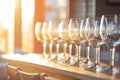 sunlight catching the hue of a full row of wine glasses at golden hour Royalty Free Stock Photo