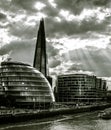 Sunlight through clouds above City Hall and The Shard