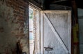 Old, broken wood door in a brick building Royalty Free Stock Photo