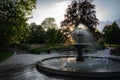 The sunlight comes through a tree during sunset hitting the fountain in the park Stadsparken in Lund, Sweden